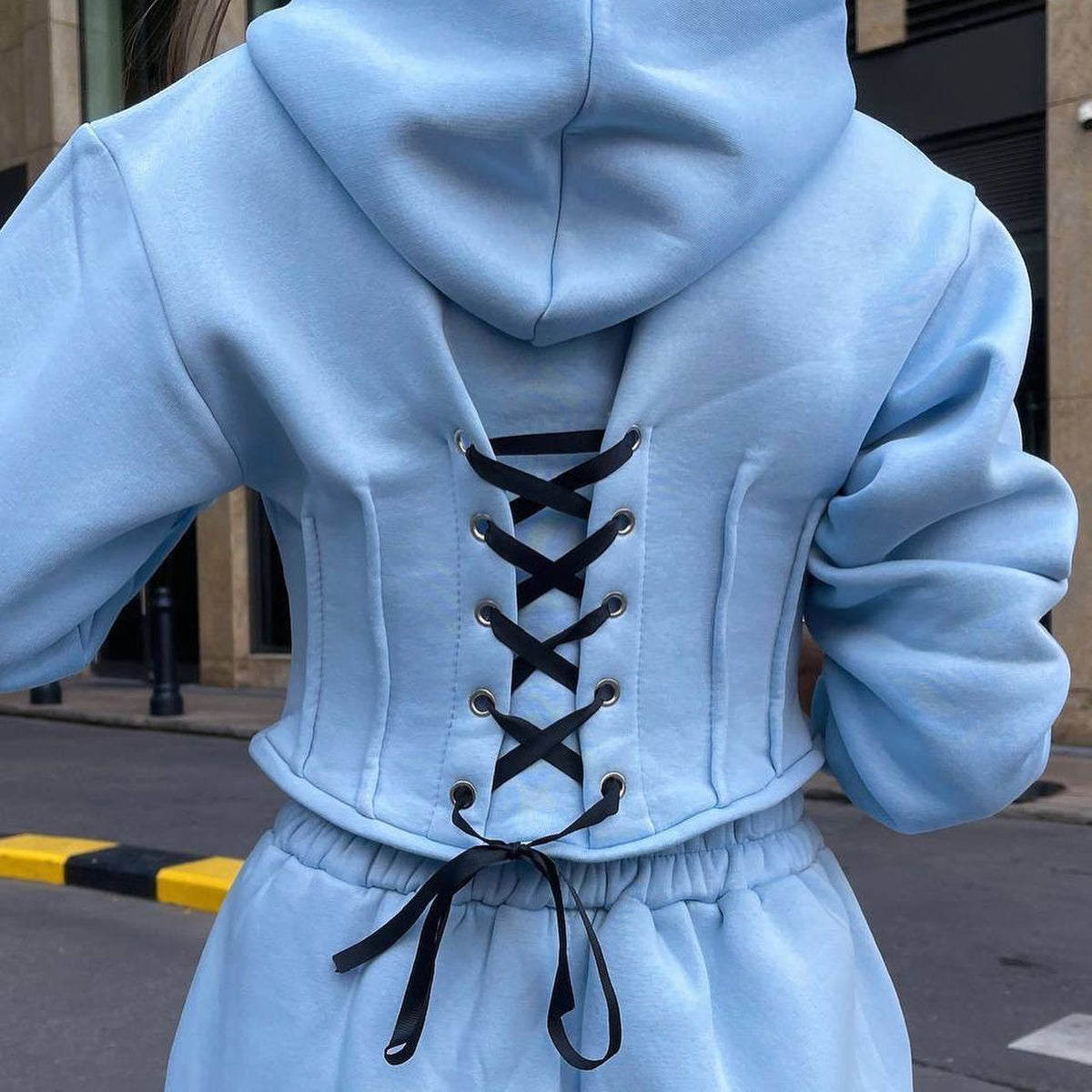 Ensemble de deux pièces. Sweat-shirt avec capuche et corset à la taille et pantalon